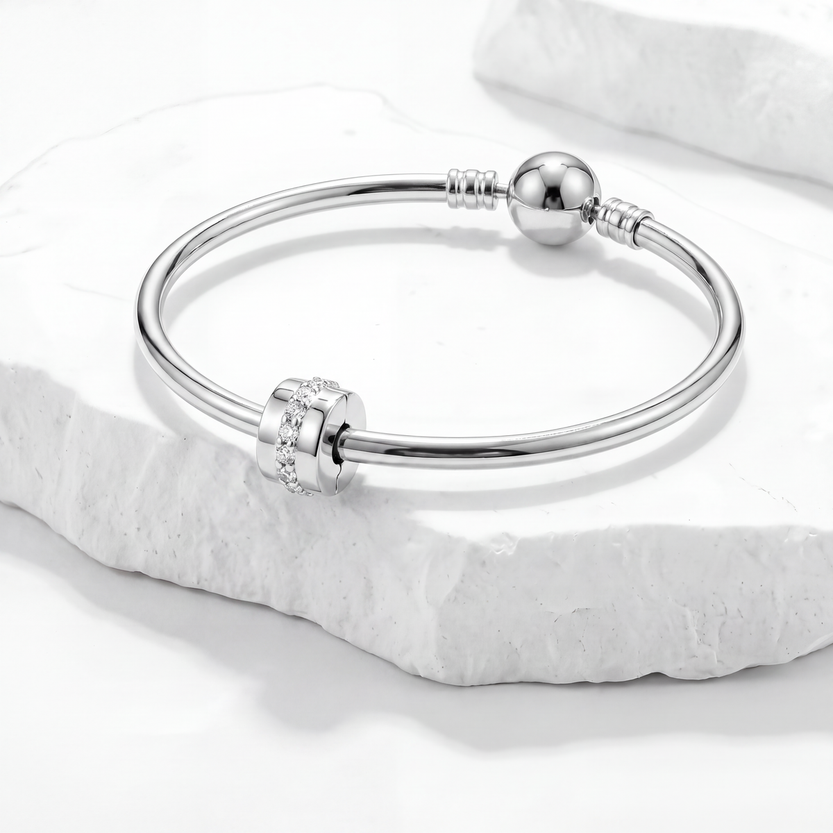 Elegant silver bracelet featuring clips and spacers, perfect for organizing charm bracelets.