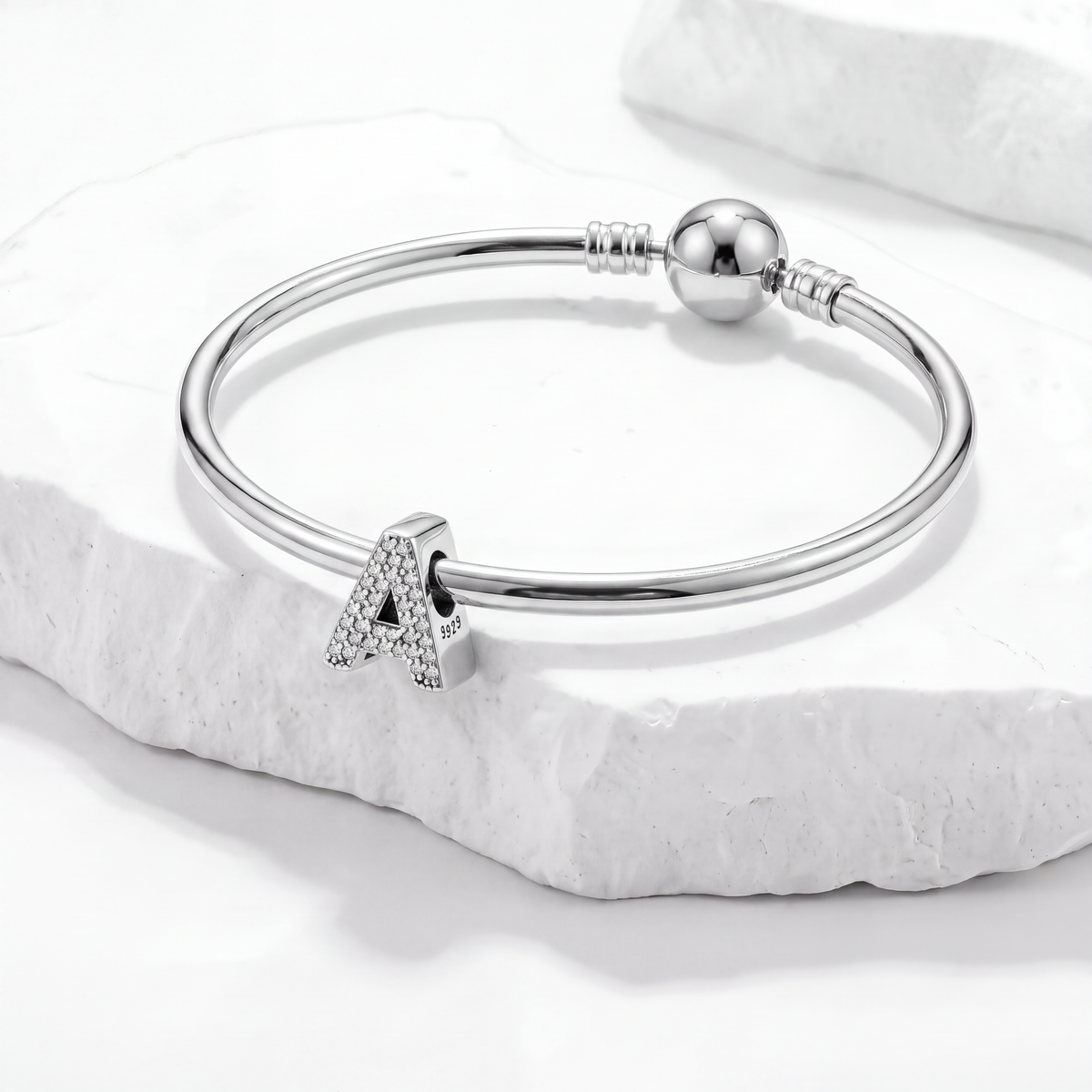 Silver bracelet featuring an alphabet charm 'A', part of a collection of alphabet charms.