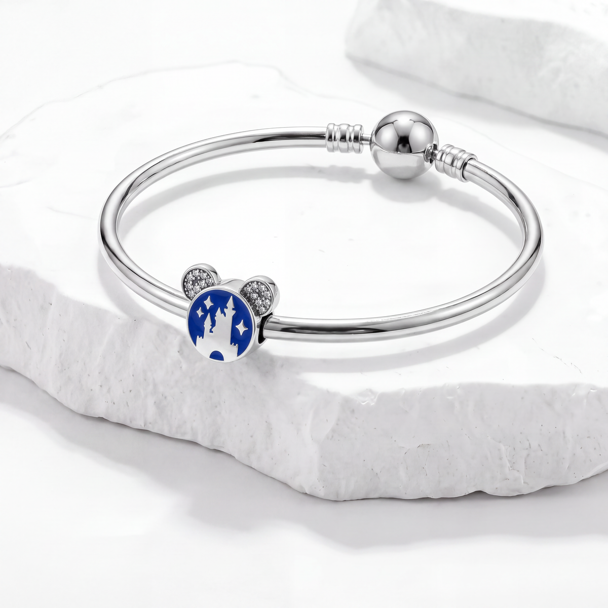Disney charms featuring a blue Mickey Mouse design with castle and stars on a silver bracelet.
