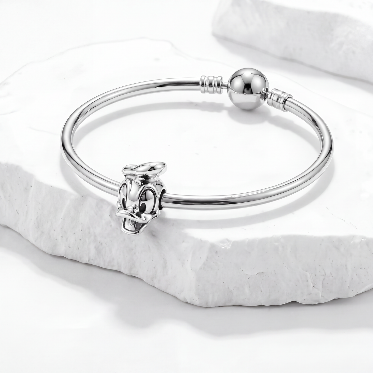 Disney charms featuring a detailed Donald Duck dangle charm on a sleek bracelet against a white background.