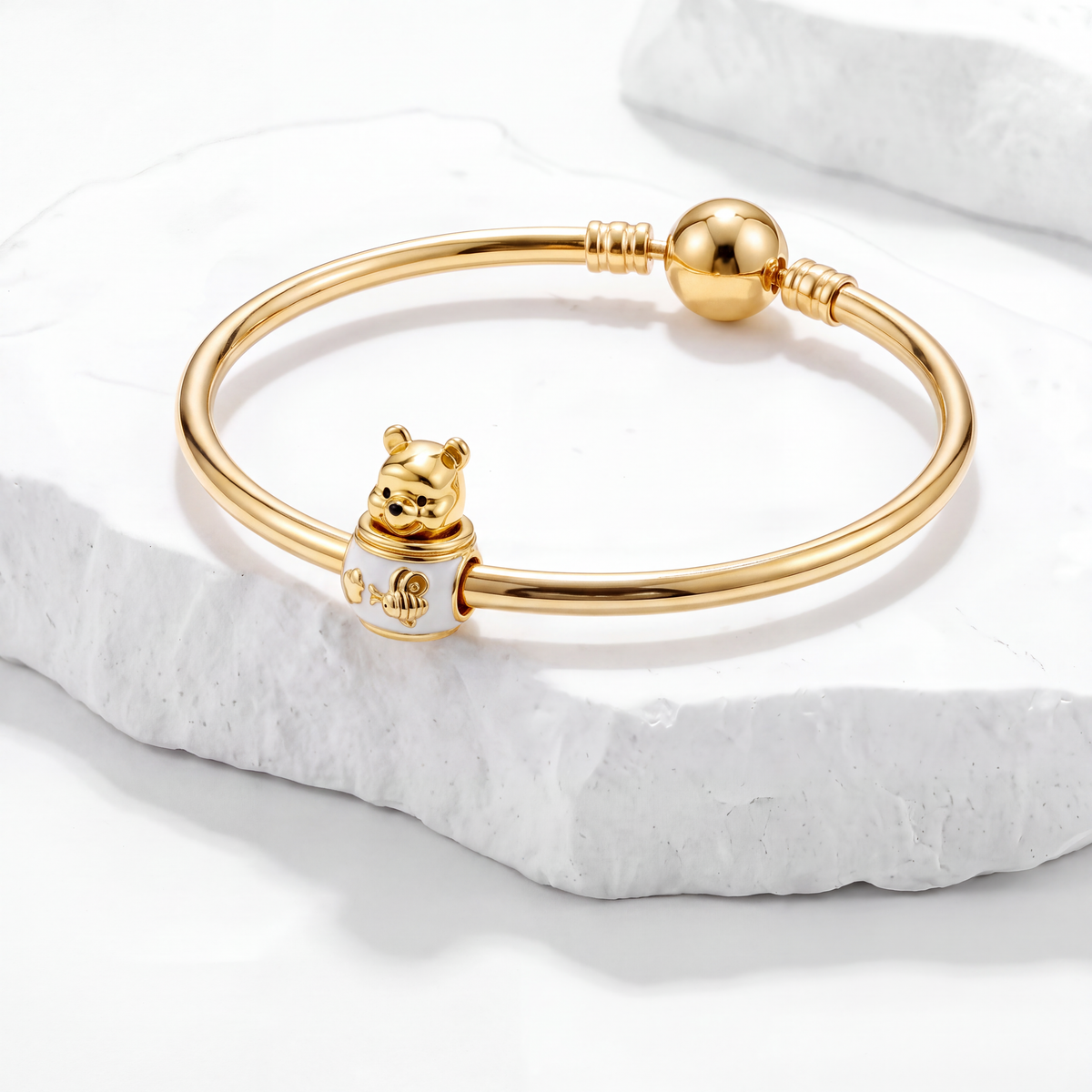 Winnie the Pooh charm bangle showcasing Disney charms on a marble surface.