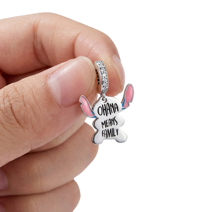Person holding Stitch Ohana Family Dangle Charm with 'Ohana Means Family' inscription.