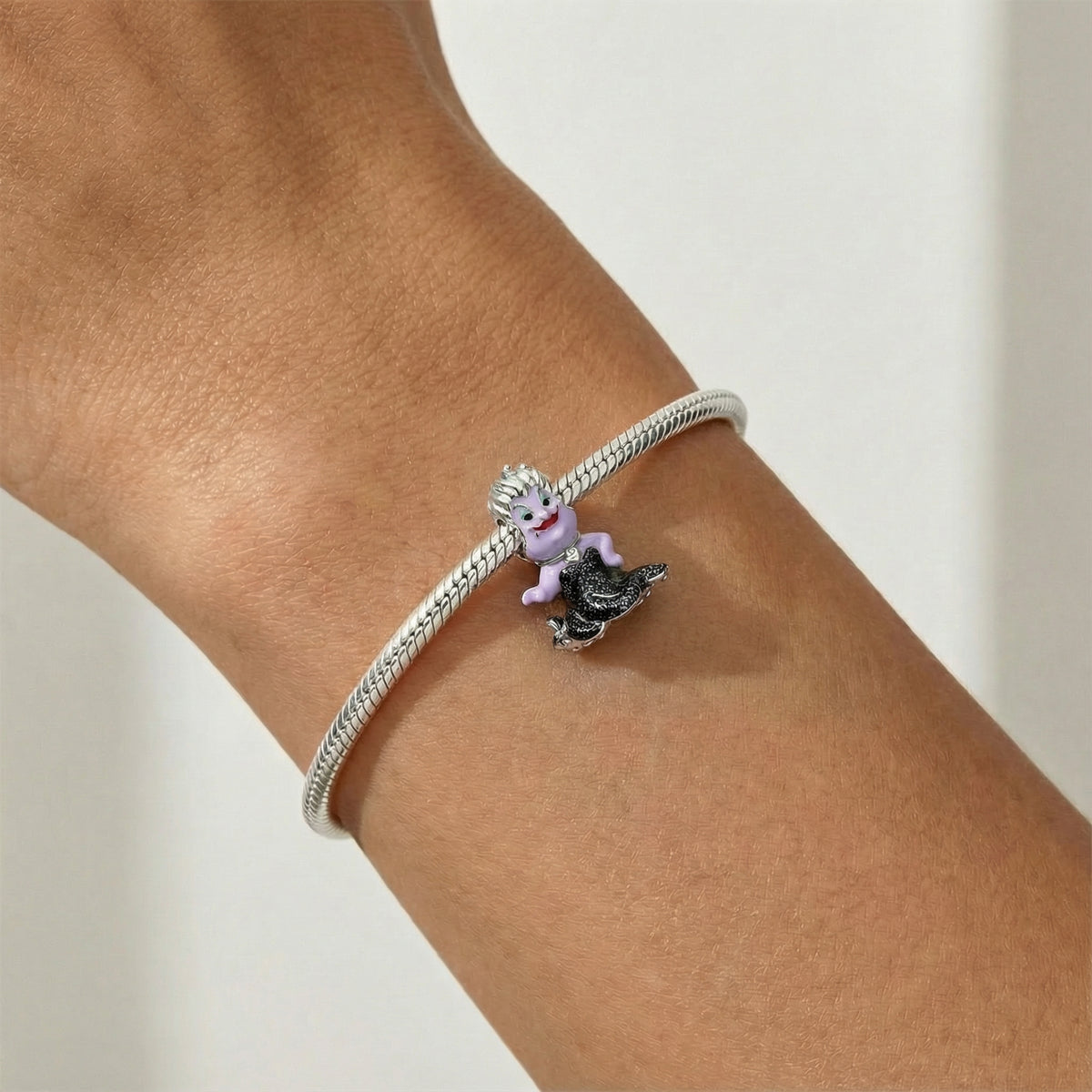 Disney The Little Mermaid Ursula Sea Witch Charm displayed on a silver bracelet against a wrist.