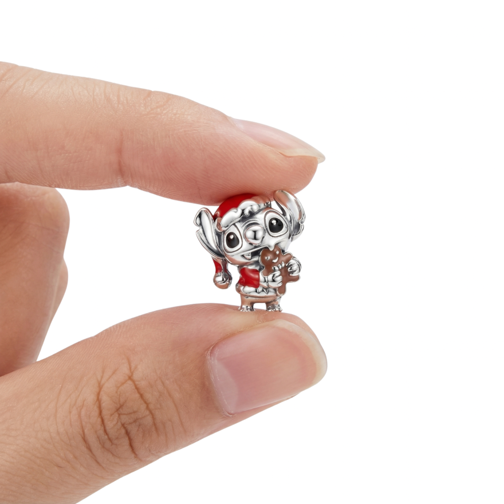 Disney Lilo and Stitch Festive Stitch Charm held in hand, featuring Stitch in a Santa hat with a gingerbread cookie.