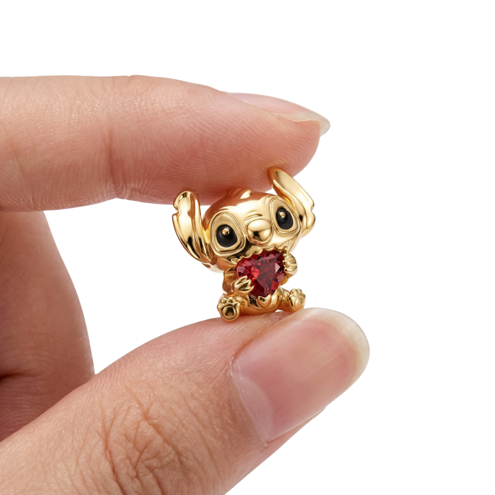 Disney Lilo and Stitch Golden Heart Charm held between fingers, showcasing Stitch with a heart-shaped gem.