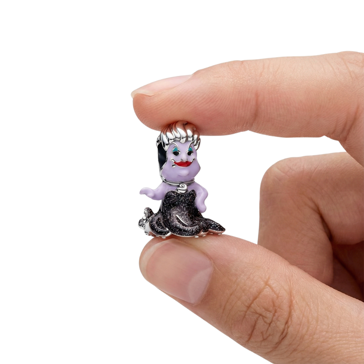 A hand holding the Disney Ursula Sea Witch Charm featuring lavender skin and black dress, inspired by The Little Mermaid.