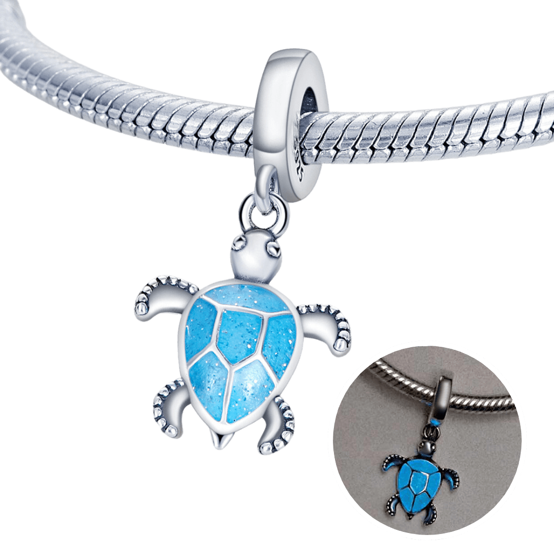 Glow In The Dark Ocean Blue Sea Turtle Dangle Charm on a silver bracelet with vibrant blue shell detail.