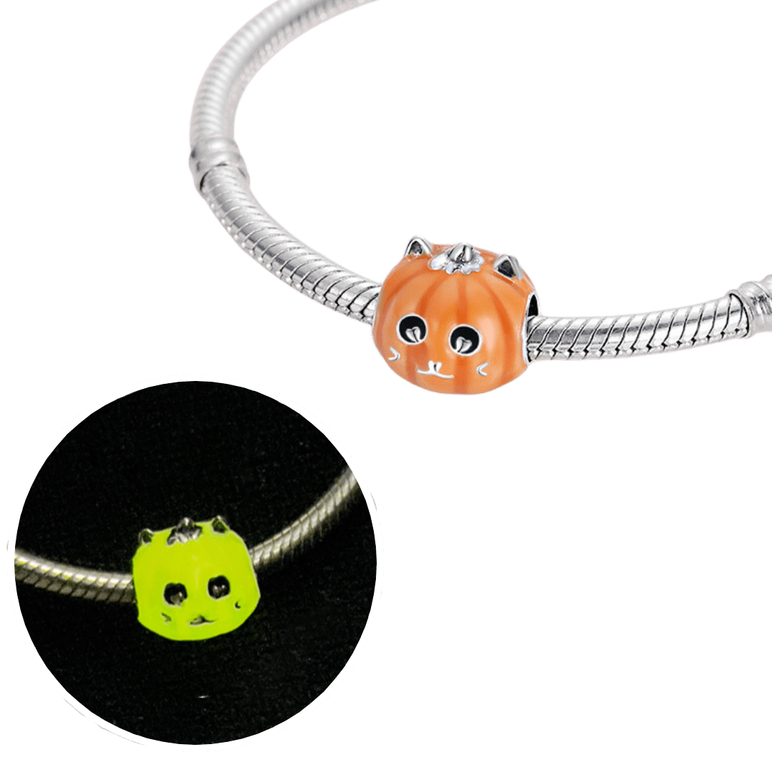 Glow Pumpkin Cat Charm ( Discontinued ) featuring an orange pumpkin with cat ears on a silver bracelet