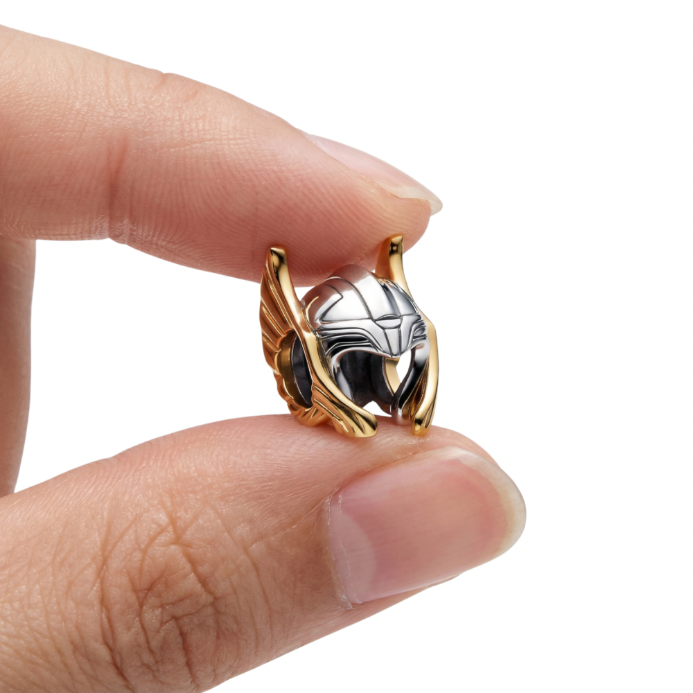 Marvel Thor Helmet Charm held between fingers, showcasing its detailed design and heroic symbolism.