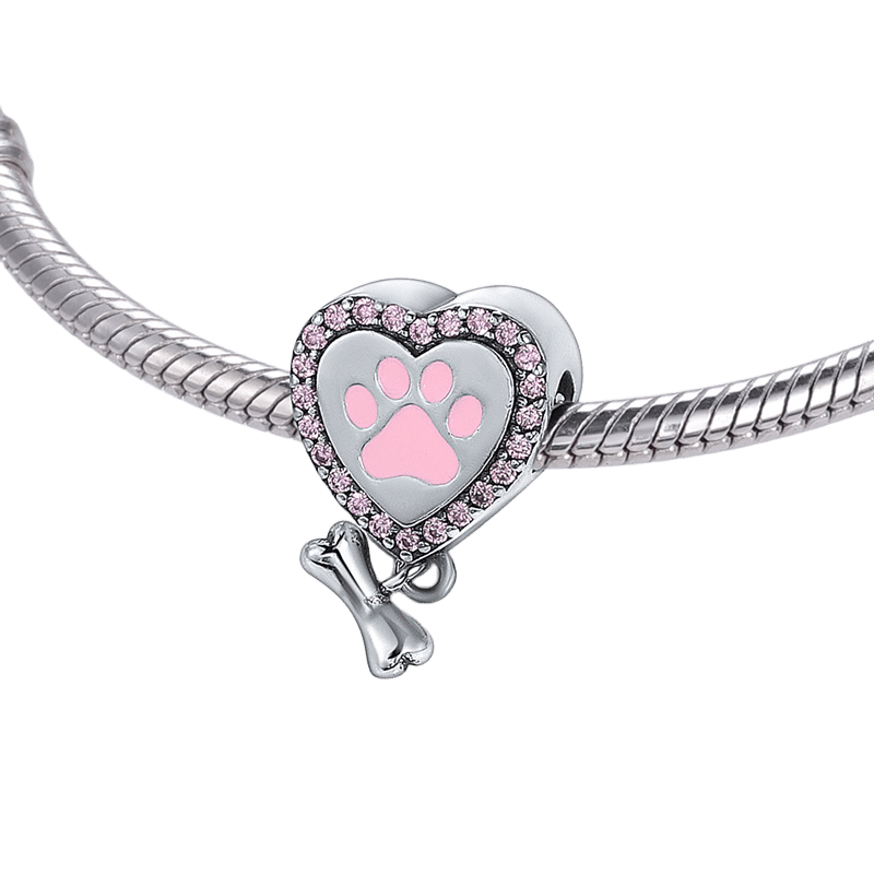 Paw Print Heart And Bone Dangle Charm featuring pink paw print and sparkling stones on a bracelet.
